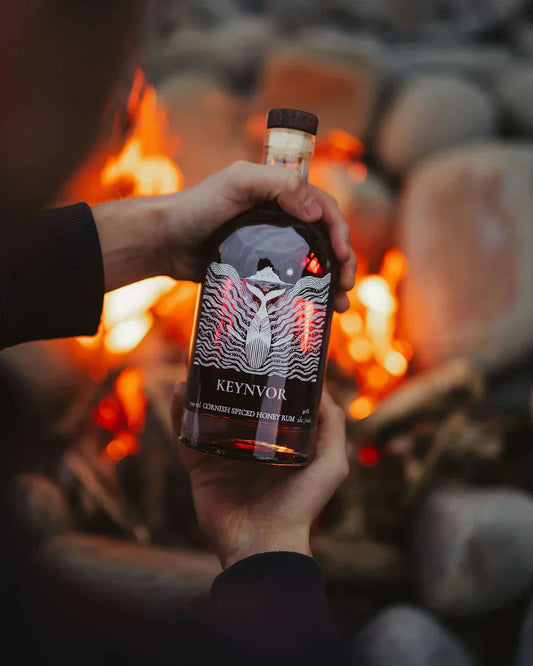 Keynvor Honey Spiced Rum held over a wood fire — Cornwall's only wood-fired distillery, Mounts Bay